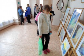 Дети рассматривают картины юных художников.
