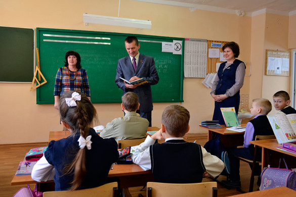 Депутат Вдовин смотрит дневник школьника МСШ №1.