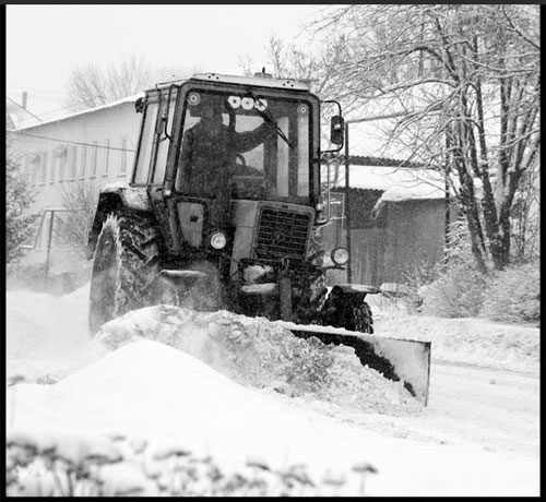 Трактор чистит снег.